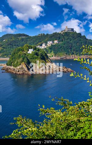 Vista de la Bahia de La Concha desde la Bateria de las Damas, la Isla Santa Clara con la Casa del Faro donde se encuentra la obra Hondalea de la escultora Cristina Iglesias, Al fondo el Monte Igeldo, Donostia, San Sebastian, Ciudad cosmopolita de 187,000 habitantes, destaca por su gastronomía, playas urbanas y edificios inspirados en la arquitectura parisina, Gipuzkoa, Baskenland, Spanien, Europa. Stockfoto