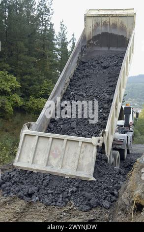 Bau eines Waldweges mit schwarzer Schlacke aus der Gießerei. Ormaiztegi, Guipúzcoa. Euskadi, Spanien. Stockfoto