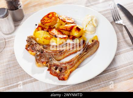 Gegrillte Lammrippchen mit goldener Kruste serviert mit gebratenen Kartoffeln. Traditionelle spanische cordero-Rippchen Stockfoto