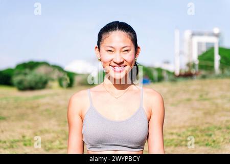 Junge Asiatin, die glücklich lächelt und in die Kamera schaut Stockfoto