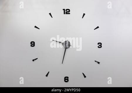 Minimalistisches Design einer Wanduhr mit schwarzen Zahlen. Stockfoto