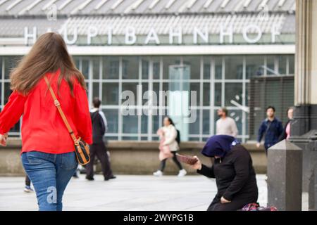 Köln, Deutschland, 07. April 2024. Ein Passant läuft an einem Bettler vor dem Kölner Dom vorbei. Stockfoto