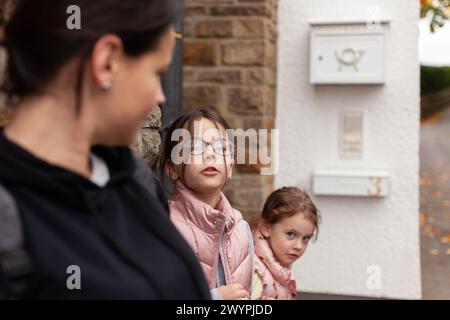 Mutter und ihre beiden Töchter sehen sich auf der Straße an. Stockfoto