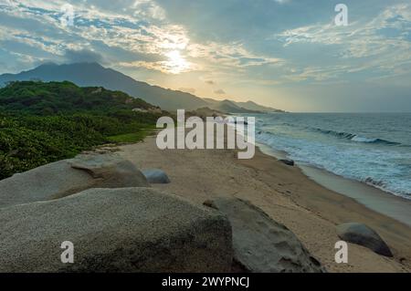 Strand bei Sonnenuntergang mit Felsblöcken, Tayrona Nationalpark, Santa Marta, Kolumbien. Stockfoto