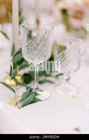Elegantes Kristallglas und goldenes Besteck auf dem Tisch Stockfoto
