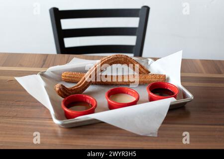 Churros auf einer Platte mit eingetauchten Saucen Stockfoto