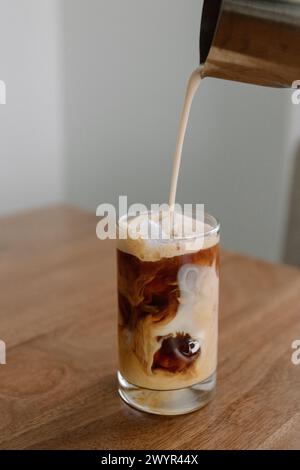 Sahne in Eiskaffee gießen Stockfoto