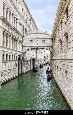 Gondeln auf einer traditionellen Bootsfahrt für Touristen auf dem Rio di Palazzo Kanal unter der berühmten Brücke der Sehenswürdigkeiten in der San Marco Gegend von Venedig, Italien Stockfoto