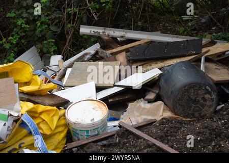 Harefield, Großbritannien. April 2024. Illegale Fliegenkippen auf einer Landstraße in Harefield, Uxbridge, obwohl es nur in der Nähe von Warnschildern für Fliegenkippen und CCTV-Überwachung liegt, die den Menschen sagen, dass sie für Fliegenkippen mit einer Geldstrafe von bis zu 20.000 £ belegt werden könnten. Quelle: Maureen McLean/Alamy Live News Stockfoto