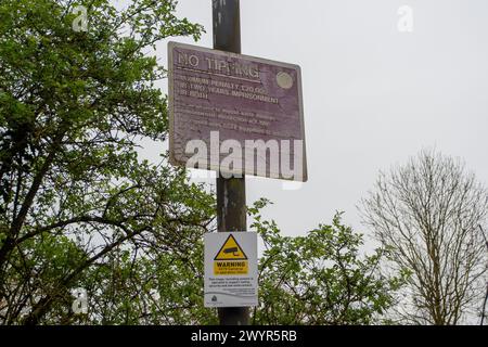 Harefield, Großbritannien. April 2024. Illegale Fliegenkippen auf einer Landstraße in Harefield, Uxbridge, obwohl es nur in der Nähe von Warnschildern für Fliegenkippen und CCTV-Überwachung liegt, die den Menschen sagen, dass sie für Fliegenkippen mit einer Geldstrafe von bis zu 20.000 £ belegt werden könnten. Quelle: Maureen McLean/Alamy Live News Stockfoto