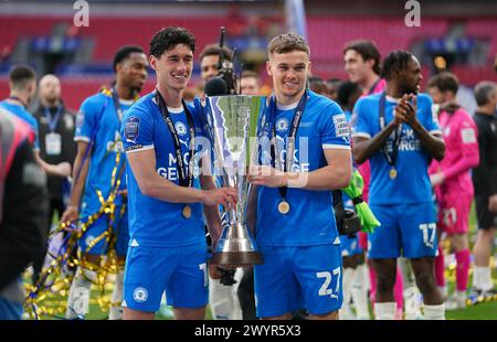 LONDON, ENGLAND – 7. APRIL: Joel Randall aus Peterborough United und Archie Collins aus Peterborough Vereinigten sich mit der EFL Trophy Trophy nach dem Bristol Street Motors Trophy Final zwischen Peterborough United und Wycombe Wanderers am 7. April 2024 im Wembley Stadium in London. (Foto: Dylan Hepworth/MB Media) Stockfoto