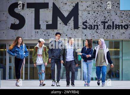 Junge Menschen, die auf der Plaza Zuloaga spazieren, Außenfassaden des San Telmo Museums, Donostia, San Sebastian, Gipuzkoa, Baskenland, Spanien. Stockfoto