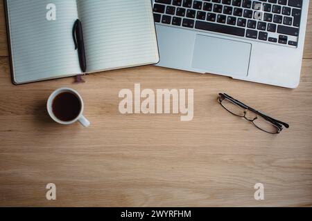 Tee, Brillen, Laptop, Notizbuch und Stift auf natürlichem Holz Textur Hintergrund Stockfoto