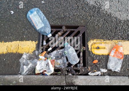 Chesham, Buckinghamshire, Großbritannien. April 2024. Plastikflaschen, die auf einem Abfluss in Chesham, Buckinghamshire, verstreut sind, fließen in einen Abfluss. Kredit: Maureen McLean/Alamy Stockfoto