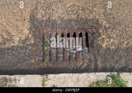 Chesham, Buckinghamshire, Großbritannien. April 2024. Überschwemmungswasser aus einem blockierten Abfluss an einer Hauptstraße in Chesham, Buckinghamshire, fließt in einen Abfluss. Kredit: Maureen McLean/Alamy Stockfoto