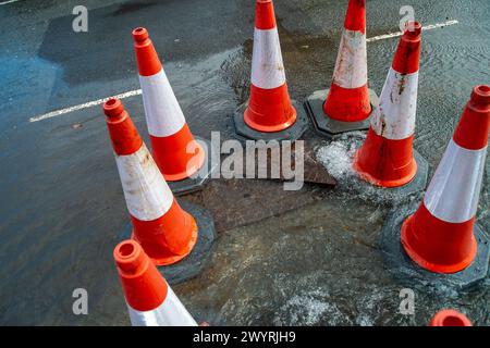 Chesham, Buckinghamshire, Großbritannien. April 2024. Wasser strömt aus einem verstopften Abfluss auf einer Hauptstraße durch Chesham, Buckinghamhire. Einige Autos fuhren schnell durch das Wasser und spritzten Passanten vorbei. Kredit: Maureen McLean/Alamy Stockfoto