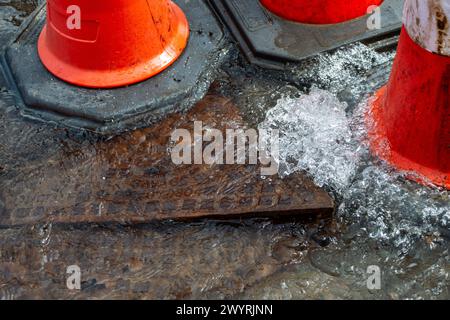 Chesham, Buckinghamshire, Großbritannien. April 2024. Wasser strömt aus einem verstopften Abfluss auf einer Hauptstraße durch Chesham, Buckinghamhire. Einige Autos fuhren schnell durch das Wasser und spritzten Passanten vorbei. Kredit: Maureen McLean/Alamy Stockfoto