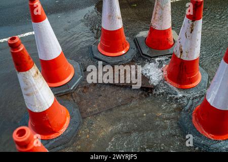 Chesham, Buckinghamshire, Großbritannien. April 2024. Wasser strömt aus einem verstopften Abfluss auf einer Hauptstraße durch Chesham, Buckinghamhire. Einige Autos fuhren schnell durch das Wasser und spritzten Passanten vorbei. Kredit: Maureen McLean/Alamy Stockfoto