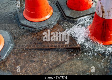 Chesham, Buckinghamshire, Großbritannien. April 2024. Wasser strömt aus einem verstopften Abfluss auf einer Hauptstraße durch Chesham, Buckinghamhire. Einige Autos fuhren schnell durch das Wasser und spritzten Passanten vorbei. Kredit: Maureen McLean/Alamy Stockfoto