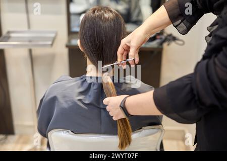 Friseur Schneiden einer Frau Haarschwanz, Haarspende-Programm, Friseursalon und Beauty Clinic. Stockfoto