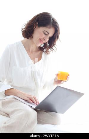 Frau, die einen Laptop benutzt und lächelt. Stockfoto