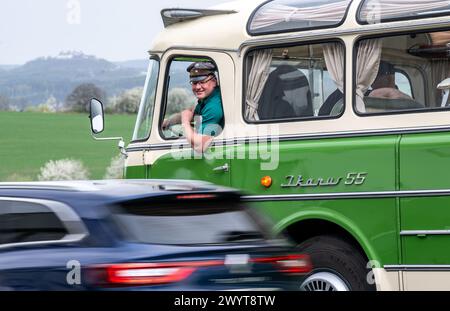 Zschopau, Deutschland. April 2024. Busfahrer Sven Mischke blickt aus einem historischen Ikarus-Bus 55,51 von 1962 vor der Augustusburg. An vier Tagen in den kommenden Monaten können Interessenten die vier sächsischen Motorradmuseen im Oldtimerbus besuchen. Quelle: Hendrik Schmidt/dpa/Alamy Live News Stockfoto