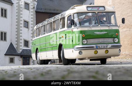 Zschopau, Deutschland. April 2024. Busfahrer Sven Mischke fährt einen historischen Ikarus-Bus 55,51 von 1962 im Innenhof von Schloss Wildeck. An vier Tagen in den kommenden Monaten können Interessenten die vier sächsischen Motorradmuseen im Oldtimerbus besuchen. Quelle: Hendrik Schmidt/dpa/Alamy Live News Stockfoto