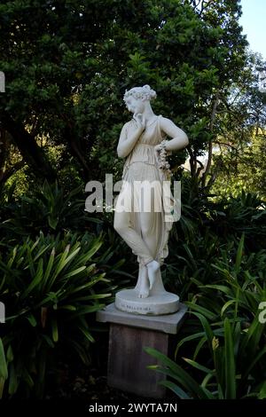 La Ballarina, eine weiße Marmorskulptur einer Tänzerin in zartem drapiertem Kostüm in einem üppig grünen Garten im Royal Botanic Gardens Sydney Stockfoto