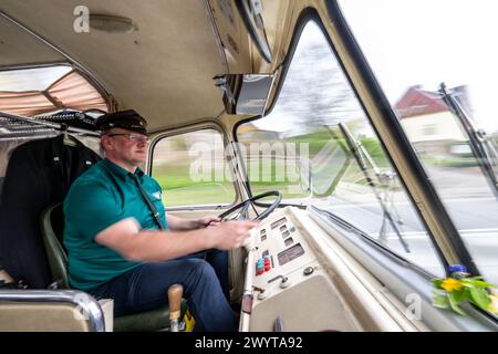 Zschopau, Deutschland. April 2024. Busfahrer Sven Mischke fährt einen historischen Ikarus-Bus 55,51 von 1962 durch die Stadt. An vier Tagen in den kommenden Monaten können Interessenten die vier sächsischen Motorradmuseen im Oldtimerbus besuchen. Quelle: Hendrik Schmidt/dpa/Alamy Live News Stockfoto