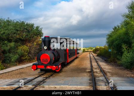 Der Retro-Zug bringt Besucher vom Festland zum Strand Barril in der Nähe von Tavira, Portugal. Stockfoto