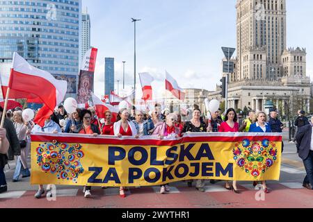 Warschau, Polen. April 2024. Demonstranten marschieren, während sie ein Banner mit der Aufschrift "Polen für Frieden" halten. Mehrere hundert Menschen, die sich in Warschau versammelt haben, um ihre Opposition gegen "Polen in den Krieg mit Russland zu drängen" zu zeigen, sind auch gegen die Hilfe der "Nazidiktatur in der Ukraine" Stockfoto