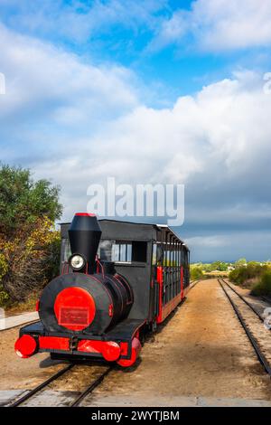 Der Retro-Zug bringt Besucher vom Festland zum Strand Barril in der Nähe von Tavira, Portugal. Stockfoto