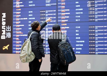 Passagiere mit Blick auf den Abflugtisch im Terminal B des Flughafens Sheremetjewo in Moskau Stockfoto