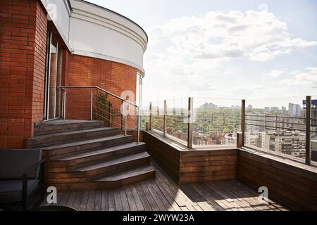 Ein Balkon bietet einen atemberaubenden Blick auf die Stadtlandschaft darunter und zeigt das geschäftige urbane Leben und die hohen Wolkenkratzer Stockfoto