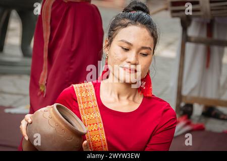 Junge Frauen in traditioneller vietnamesischer Kleidung, die traditionelle vietnamesische Tänze mit einem Tontopf auf dem Kopf aufführen. Asiatische Frauen - Street Perfo Stockfoto