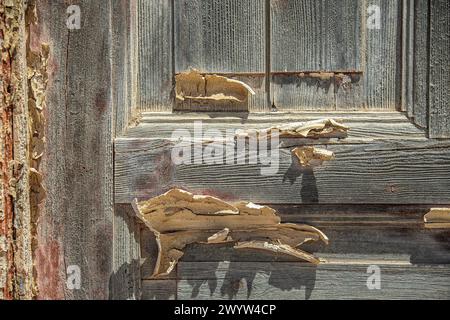 Creme-Farbe, die fast vollständig von einer Tür entfernt wurde, vom Wüstensand im Bergbaudorf Bogenfels, Namibia. Stockfoto