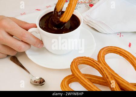 Mann mit Schokolade mit Churros. Schließen Sie die Ansicht. Stockfoto