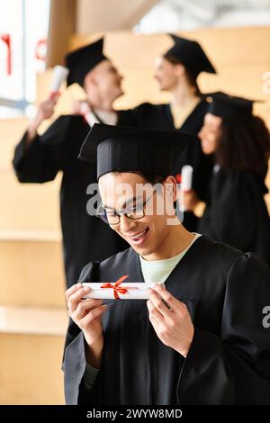 Ein vielseitiger Mann in einem Abschlusskleid, der freudig sein Diplom hält. Stockfoto
