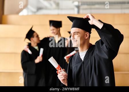 Ein vielseitiger Mann, der mit einer Abschlussmütze und einem Kleid gekleidet ist, hält stolz ein Diplom mit einem strahlenden Lächeln, was auf akademischen Erfolg hinweist. Stockfoto