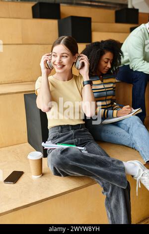 Eine multikulturelle Frau, vielleicht eine afroamerikanische Studentin, sitzt auf Stufen und spricht mit einem Handy. Stockfoto