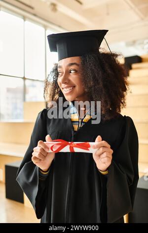 Eine Afroamerikanerin in Mütze und Kleid, die ihre akademische Leistung feiert. Stockfoto