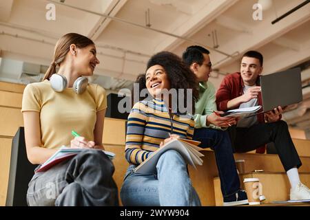 Eine multikulturelle Gruppe von Studenten, darunter ein afroamerikanisches Mädchen, die aktiv an einem Vortrag an einer Universität teilnimmt. Stockfoto