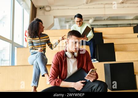 Verschiedene Gruppen junger Menschen, die im Vortragssaal auf Stufen saßen, diskutierten Stockfoto