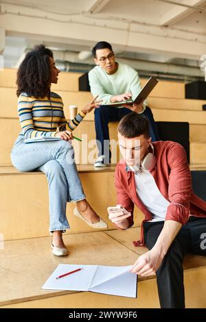 Eine multikulturelle Gruppe von Studenten, darunter afroamerikanische Mädchen, sitzt aufmerksam im Hörsaal der Universität Stockfoto