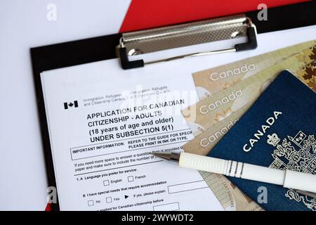 Antrag auf kanadische Staatsbürgerschaft für Erwachsene auf Tisch mit Stift, Reisepass und Dollarscheine in Nahaufnahme Stockfoto
