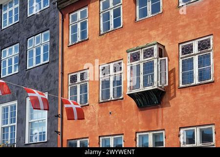 Dänische Flagge und alte Fenster in einem bunten Gebäude in Kopenhagen, Dänemark Stockfoto