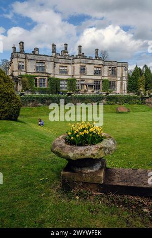 Ein kleines Mädchen pflückt an einem Frühlingstag in den Gärten von Thornbridge Hall, Ashford-im-Wasser, in der Nähe von Bakewell, Derbyshire Stockfoto