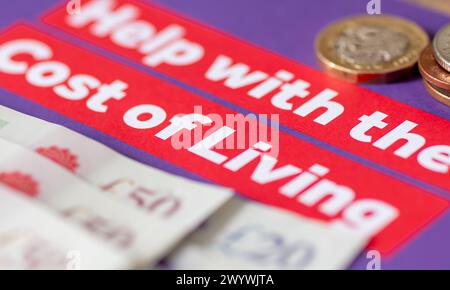 Eine Makroaufnahme eines Regierungsbroschüren mit Hilfe der Lebenshaltungskosten mit Banknoten und Münzen. Ein Konzept der Lebenshaltungskosten und der Armut. Stockfoto