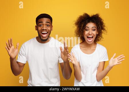 afroamerikanische Partner freuen sich über Erfolg, ballen Fäuste und rufen aus Stockfoto