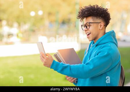 Junger Mann, der Selfie macht, während er im Freien liest Stockfoto